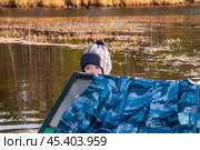 Мальчик в лодке. Его отец рядом ловит рыбу сетями, а он внимательно смотрит.. Их родовое имение находится в лесу ( недалеко от реки ). Они, коренные жители народов севера - ханты, здесь живут годами. Основные продукты - самые, что ни на есть натуральные. Все остальное покупают раз в месяц, в городе. Сообщение с городом круглый год по реке , километров 20-25... (2011 год). Редакционное фото, фотограф Павел Просянов / Фотобанк Лори