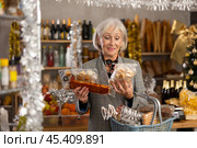 Elderly woman choosing marzipan and panellets in grocery store. Стоковое фото, фотограф Яков Филимонов / Фотобанк Лори