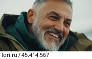 Теплые и ободряющие улыбки зрелого мужчины, приветствующего весну на свежем воздухе. Стоковое AI-изображение, AI-художник ФотоИнтеллект / Фотобанк Лори