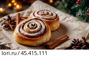 The cinnabons. Close-up of cinnamon buns. Beautiful buns with fresh cinnamon and icing on a wooden table. Fragrant homemade New Year's pastries. Стоковое AI-изображение, AI-художник Photojuli / Фотобанк Лори