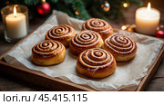 The cinnabons. Close-up of cinnamon buns. Beautiful buns with fresh cinnamon and icing on a wooden table. Fragrant homemade New Year's pastries. Стоковое AI-изображение, AI-художник Photojuli / Фотобанк Лори