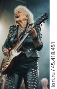 An elderly rock musician plays electric guitar on stage. Стоковое AI-видео, аниматор Юрий Поздников / Фотобанк Лори