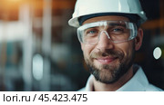 A male construction worker in a hard hat and safety glasses at a construction site. Стоковое AI-изображение, AI-художник Виктория Тельминова / Фотобанк Лори