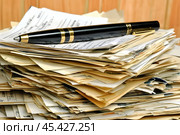 A pile of disorganized papers rests beneath an elegant pen, showcasing the beauty of creativity. Стоковое AI-изображение, AI-художник Елена Старчак / Фотобанк Лори