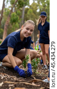 Teen volunteers plant trees in a community park, fostering environmental stewardship, AI. Стоковое AI-изображение, AI-художник Сергей Старуш / Фотобанк Лори