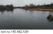 The camera flies low over the surface of a cold autumn river along the shore and dives under a railway bridge. Then she rises above the water and turns around and flies over the bridge, revealing a panorama of the river landscape from a bird's-eye view. Стоковое видео, видеограф Ярославский Максим / Фотобанк Лори