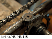 Bicycle chain engaging with dirty grunge crankset and chainring. Стоковое AI-изображение, AI-художник Иван Рябоконь / Фотобанк Лори