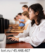Portrait of fifteen-year-old schoolgirl studying at computer in class at an informatics lesson with classmates. Стоковое фото, фотограф Яков Филимонов / Фотобанк Лори
