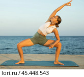 On windy day young slender woman does yoga near sea doing utkata konasana. Стоковое фото, фотограф Яков Филимонов / Фотобанк Лори