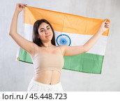 Happy young woman with flag of India against unicoloured background. Стоковое фото, фотограф Яков Филимонов / Фотобанк Лори