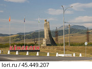 Монумент героям Гражданской и Великой Отечественной войн, село Кёнделен, Кабардино-Балкарская Республика (Кабардино-Балкария), Северный Кавказ, Россия. Вид на скульптуру скорбящего горца. Памятник погибшим в 1917-1921 и 1941-1945 годы. Около дороги большая надпись с названием села Кёнделен. (2024 год). Редакционное фото, фотограф Андрей Степанов / Фотобанк Лори