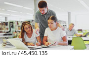 Friendly happy group of students preparing together for exam in modern university library. Стоковое видео, видеограф Яков Филимонов / Фотобанк Лори
