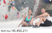 Joyful woman and man share their impressions of climbing climbing wall while sitting on bench in a recreation area. Стоковое видео, видеограф Яков Филимонов / Фотобанк Лори