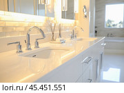 Modern white bathroom vanity with chrome faucets and tile backsplash illuminating luxury. Стоковое AI-изображение, AI-художник Юрий Поздников / Фотобанк Лори