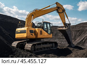 Mining excavator loading coal working in quarry mines open pit under blue sky. Digging machine works in coal mine, hauling minerals. Heavy metallurgy loads mine machinery concept. Copy ad text space. Стоковое AI-изображение, AI-художник Aleksandr Golubev / Фотобанк Лори