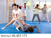 Teenage girl practicing painful armlock in sparring with instructor at self defence training. Стоковое фото, фотограф Яков Филимонов / Фотобанк Лори