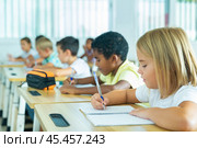 Side view of schoolkids group working on lecture in classroom. Стоковое фото, фотограф Яков Филимонов / Фотобанк Лори