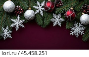 Festive Christmas decorations featuring red and silver ornaments with pinecones and snowflakes on lush green branches. Christmas card with empty space for greetings. Стоковое AI-изображение, AI-художник Людмила Лесовая / Фотобанк Лори