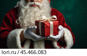 Hands of Santa Claus in close-up with a gift box in his hands on a green background. Gifts from Santa Claus. Стоковое AI-изображение, AI-художник Photojuli / Фотобанк Лори