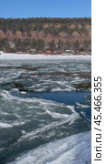 Vertical video of Siberian river Irkut in November during freeze-up. Ice floes float on water. On shore is Shamanka village near famous Shamansky cliff, called 33 heroes bogatyrs - natural landmark. Стоковое видео, видеограф Виктория Катьянова / Фотобанк Лори