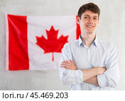 Young guy posing in front of Canadian flag. Стоковое фото, фотограф Татьяна Яцевич / Фотобанк Лори