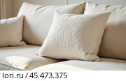 A cushion made of textured boucle fabric, against a background of other pillows. Стоковое AI-изображение, AI-художник Ольга Губская / Фотобанк Лори