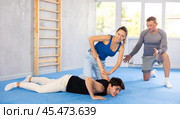 Woman learns to make power grab against male attacker under guidance of trainer. Self-defense class. Стоковое фото, фотограф Яков Филимонов / Фотобанк Лори
