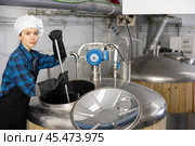 Woman brewmaster mixing beer in tank. Стоковое фото, фотограф Яков Филимонов / Фотобанк Лори