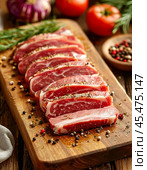 On the kitchen table on a wooden board lie pieces of thinly sliced ​​raw pork tenderloin sprinkled with spices on top. Enjoy your meal! Стоковое AI-изображение, AI-художник Сергей Елизарьев / Фотобанк Лори