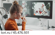 Neural network gradually creates image on monitor screen. Young female designer drinks coffee in comfortable home office, watches and evaluates created New Year image for compliance with prompt task. Стоковое AI-видео, аниматор Енваев Андрей / Фотобанк Лори