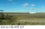 A truck with a red cab drives along the road. A truck with a red cab and blue trailer drives on a road among fields. Стоковое видео, видеограф Vladislav Baranov / Фотобанк Лори