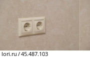 Hand plugging a black electrical plug into a white wall socket. Close-up photography of an electrical connection concept. Стоковое видео, видеограф Андрей Журавлев / Фотобанк Лори