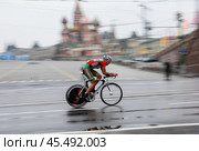 Велосипедный спорт шоссе. Российский спортсмен на трассе городского этапа велогонки "Пять Колец Москвы" на фоне Кремля и Красной площади. 5 мая 2013, Россия, Москва, Кремль (2024 год). Редакционное фото, фотограф Elena Popova / Фотобанк Лори