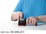 A knife sharpener. A man sharpens a knife on a special universal knife sharpener. Стоковое фото, фотограф Александр Поташев / Фотобанк Лори