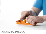 A knife sharpener. A man sharpens a knife on a special universal knife sharpener. Стоковое фото, фотограф Александр Поташев / Фотобанк Лори