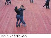 Moscow, Russia - April 20, 2019: Cute heterosexual couple of men and women dance in public park. Leisure concept. Редакционное фото, фотограф YuryKara / Фотобанк Лори