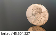 Moscow November 24 2024, Nobel Prize. Award - gold medal with image of Alfred Nobel on black background. Concept of Nobel Prize in Physics, Chemistry, Medicine. Редакционное фото, фотограф Скрипачев Антон / Фотобанк Лори