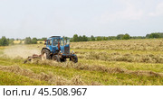 "Agricultural machinery in dusty field", "Tractor working on farmland", "Spring cultivation process", "Rural farming scene", Трактор с ворошилкой. Стоковое фото, фотограф Сергей Расторгуев / Фотобанк Лори