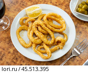 Calamar a la romana, coated deep-fried squid rings with lemon and olives. Стоковое фото, фотограф Яков Филимонов / Фотобанк Лори