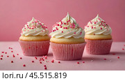 Festive cupcakes, baked with pastry sprinkles on a pink background with sequins, ideal for romantic celebrations. Valentine's Day, wedding. Стоковое AI-изображение, AI-художник Photojuli / Фотобанк Лори