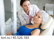 Young doctor doing RF lifting procedure for face lifting of adult woman laying in spa center. Smoothes wrinkles and tightens skin machine. Стоковое фото, фотограф Яков Филимонов / Фотобанк Лори