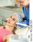 Young girl getting facial rf-lifting procedure of smoothes wrinkles and tightens skin on face in beauty salon. Concept of professional cosmetology. Стоковое фото, фотограф Яков Филимонов / Фотобанк Лори