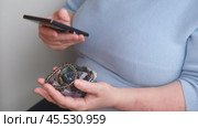 An elderly woman with a stone ring on her finger uses a smartphone. Online store of stone jewelry. Стоковое видео, видеограф Терехова Марина / Фотобанк Лори