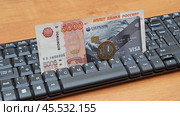 Купюра 5000 рублей, монета и банковская карта лежат на компьютерной клавиатуре. Стоковое фото, фотограф Цибаев Алексей / Фотобанк Лори