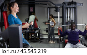 Caucasian woman doing leg raises on captains chair in gym. Стоковое фото, фотограф Яков Филимонов / Фотобанк Лори