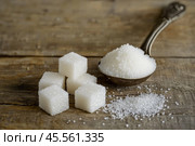 Sugar pile in a metal spoon on a wood surface. White granulated sugar and cubes. Natural seasoning. Refined sugar poured on wooden rustic table. Sugary sand. Cooking, cosmetology, spa services concept. Стоковое AI-изображение, AI-художник Марина Демидюк / Фотобанк Лори