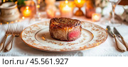 Sizzling grilled filet mignon steak served on elegant plate in romantic candlelit setting. Стоковое AI-изображение, AI-художник Юрий Поздников / Фотобанк Лори