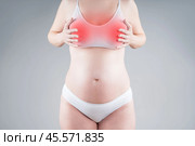 Breast pain during pregnancy, swelling of mammary glands, breastfeeding concept on gray background. Стоковое фото, фотограф Станислав Тарко / Фотобанк Лори