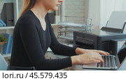 Woman using printer to print documents in modern home office with laptop on desk and organized workspace. Стоковое видео, видеограф Сергей Толмачёв / Фотобанк Лори