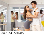 Young woman dances incendiary tango with man partner during choreography lesson. Стоковое фото, фотограф Яков Филимонов / Фотобанк Лори